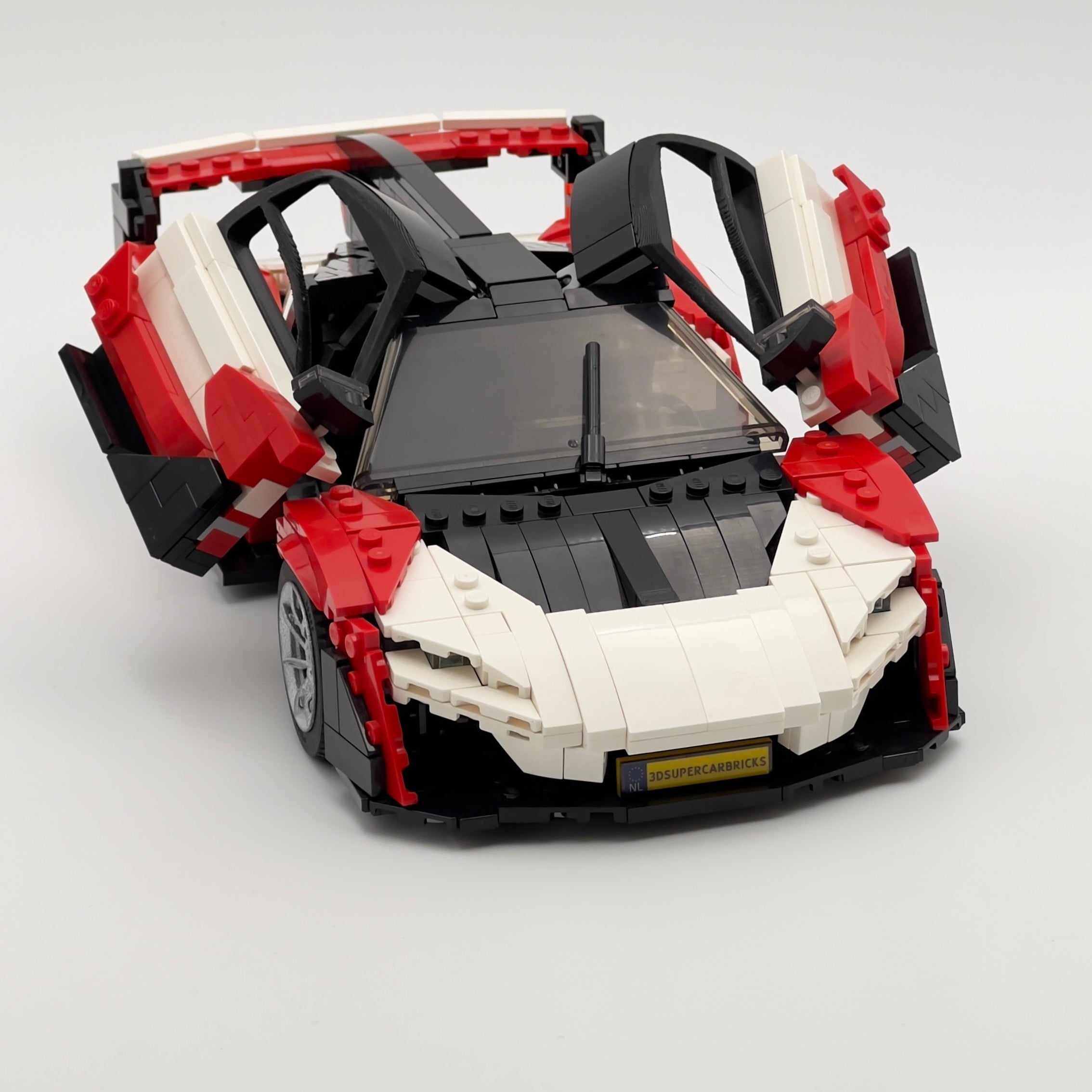 Red and white toy car model on a light gray background